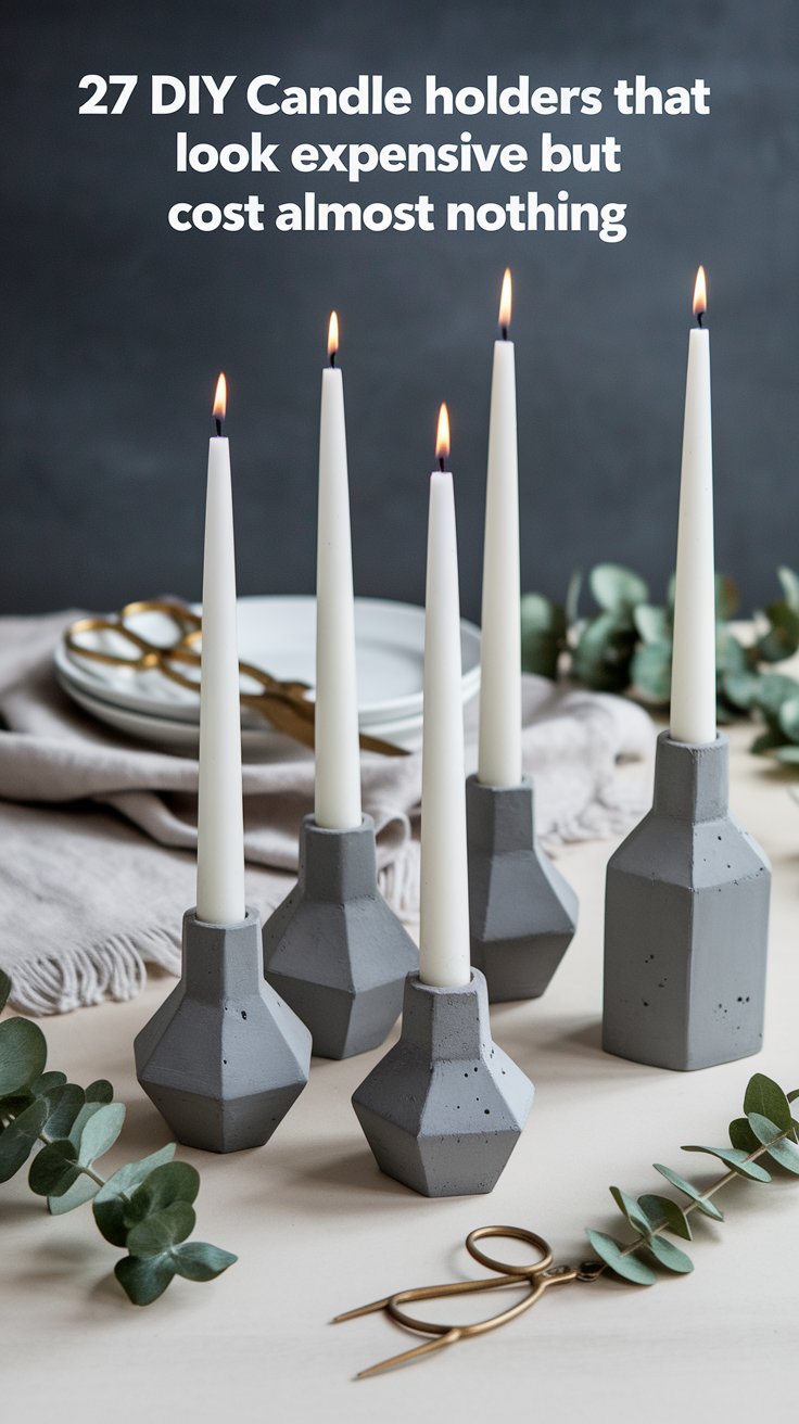 A modern DIY candle display featuring five white taper candles in geometric, concrete-style holders set on a neutral table with eucalyptus sprigs and gold scissors nearby. The text above reads, "27 DIY Candle holders that look expensive but cost almost nothing," highlighting the elegant yet budget-friendly aesthetic.